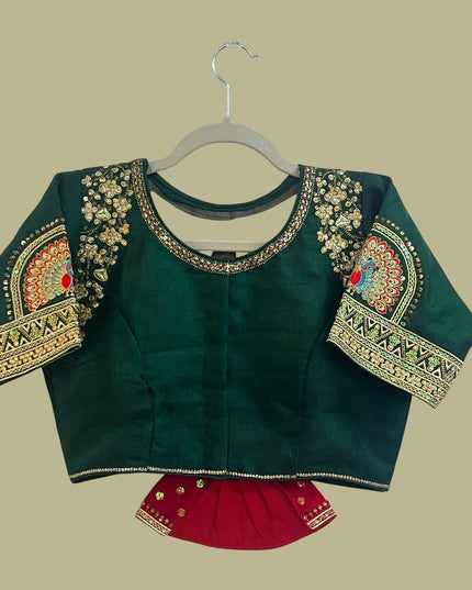 House Of Indian Wedding Attire deep green silk wedding blouse with gold embroidery, sequins, and colorful peacock motifs on sleeves.