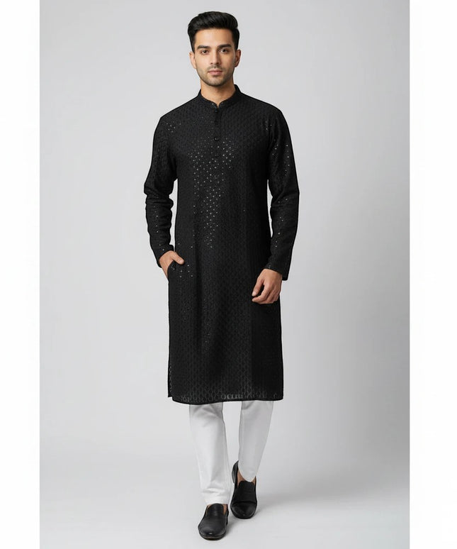 Man wearing a Kurti Connection USA black embroidered traditional kurta with a mandarin collar and white trousers.