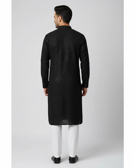 Back view of a man wearing a black Kurti Connection USA embroidered kurta with a mandarin collar and white trousers.