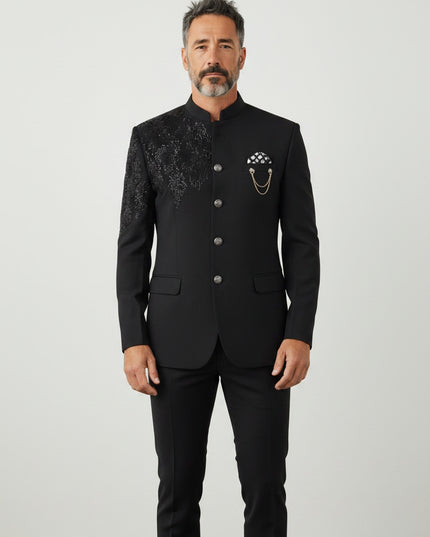 Kurti Connection USA men's black Indo Western sherwani with intricate shoulder embroidery and a decorative chain brooch.