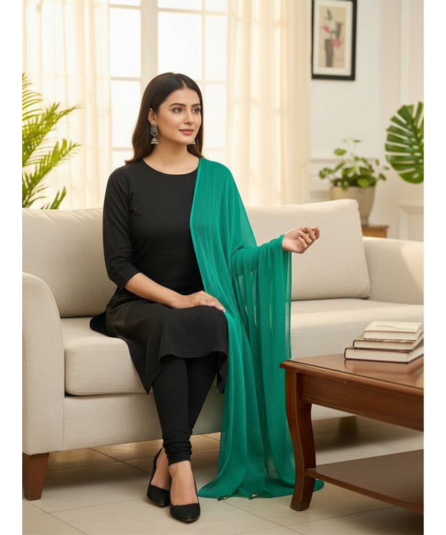Model wearing a Kurti Connection USA emerald green chiffon dupatta draped over a black ethnic outfit on a sofa