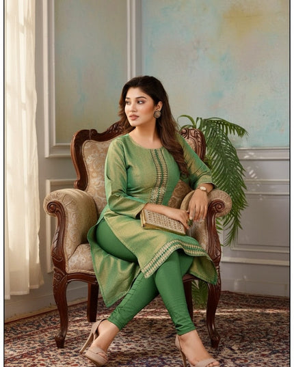 Kurti Connection USA green tissue silk kurti with intricate embroidery, worn by a model sitting in a vintage chair.