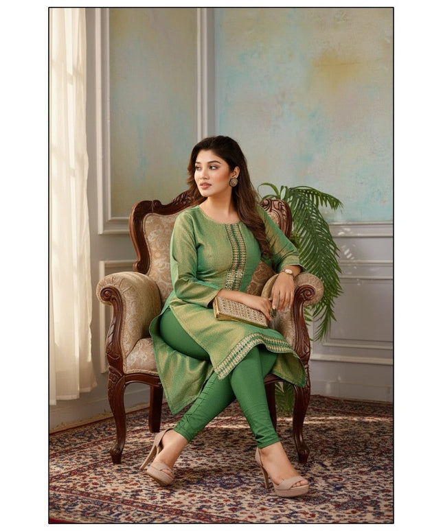 Kurti Connection USA green tissue silk kurti with intricate embroidery, worn by a model sitting in a vintage chair.