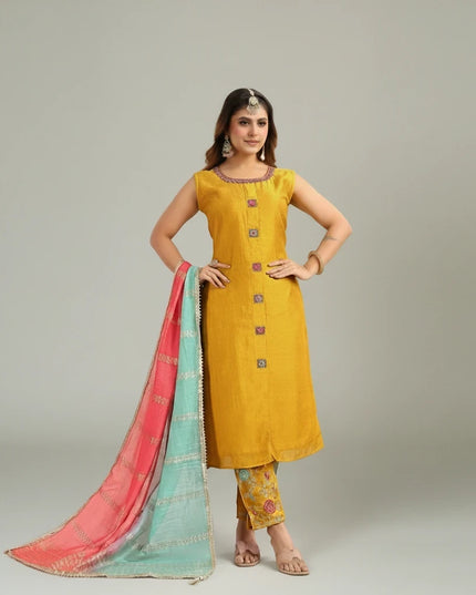 Kurti Connection USA mustard yellow sleeveless silk kurta set with floral trousers and a pink and turquoise dupatta.