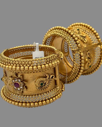 Kurti Connection USA ornate gold-tone bangle bracelets with peacock motifs, ruby and emerald stones, and filigree work.