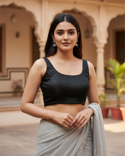 Kurti Connection USA sleeveless black ethnic blouse with a scoop neckline worn by a woman with a grey saree