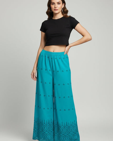 Model wearing Kurti Connection USA teal wide-leg palazzo trousers with intricate embroidery and a scalloped hem