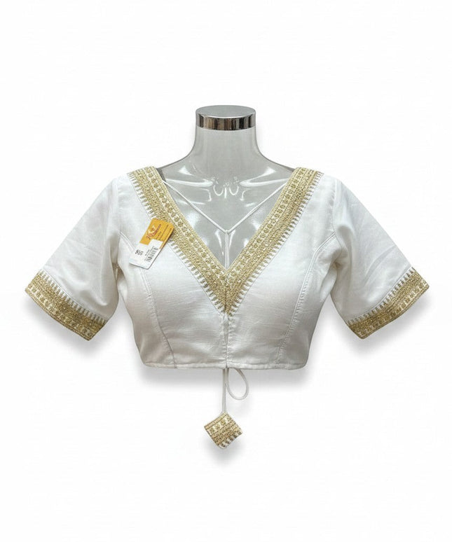 Kurti Connection USA white ethnic blouse with V-neck, half-sleeves, and intricate gold embroidery detailing.